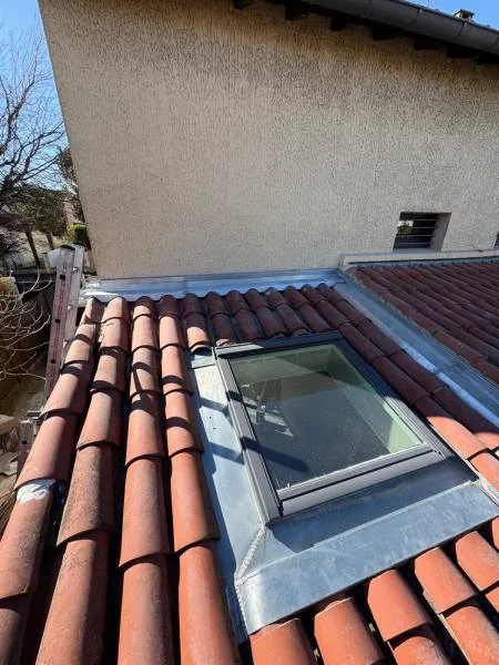 Fenêtre de toit installée dans un pan de couverture en tuiles