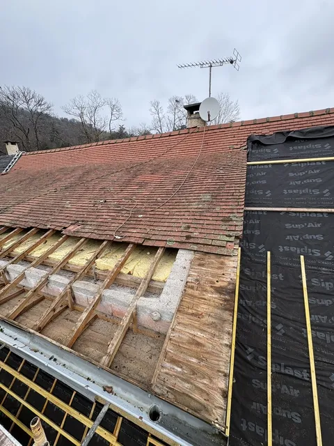 Zone de toiture déposée à côté des anciennes tuiles, avec support et liteaux apparents